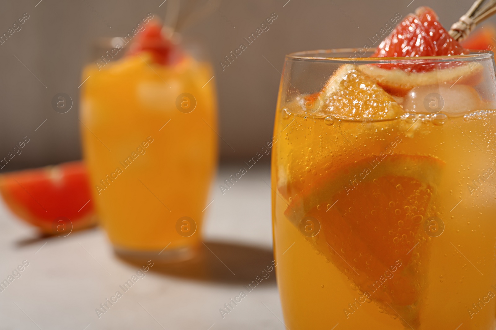 Photo of Delicious orange soda water on light background, closeup