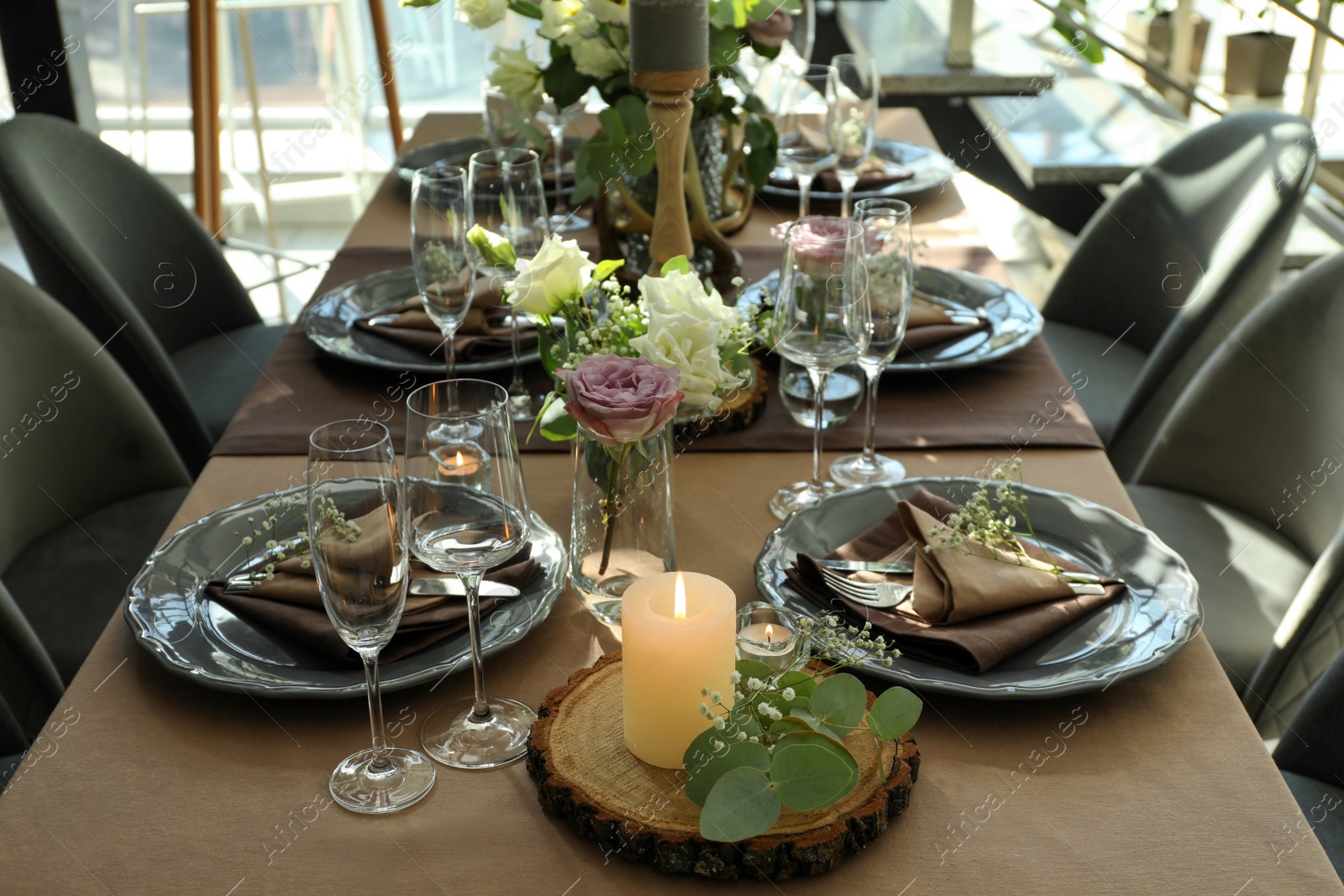 Photo of Festive table setting with beautiful tableware and floral decor in restaurant