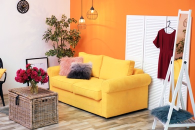Photo of Elegant living room interior with yellow sofa and folding screen