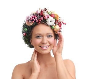 Beautiful young woman wearing Christmas wreath on white background