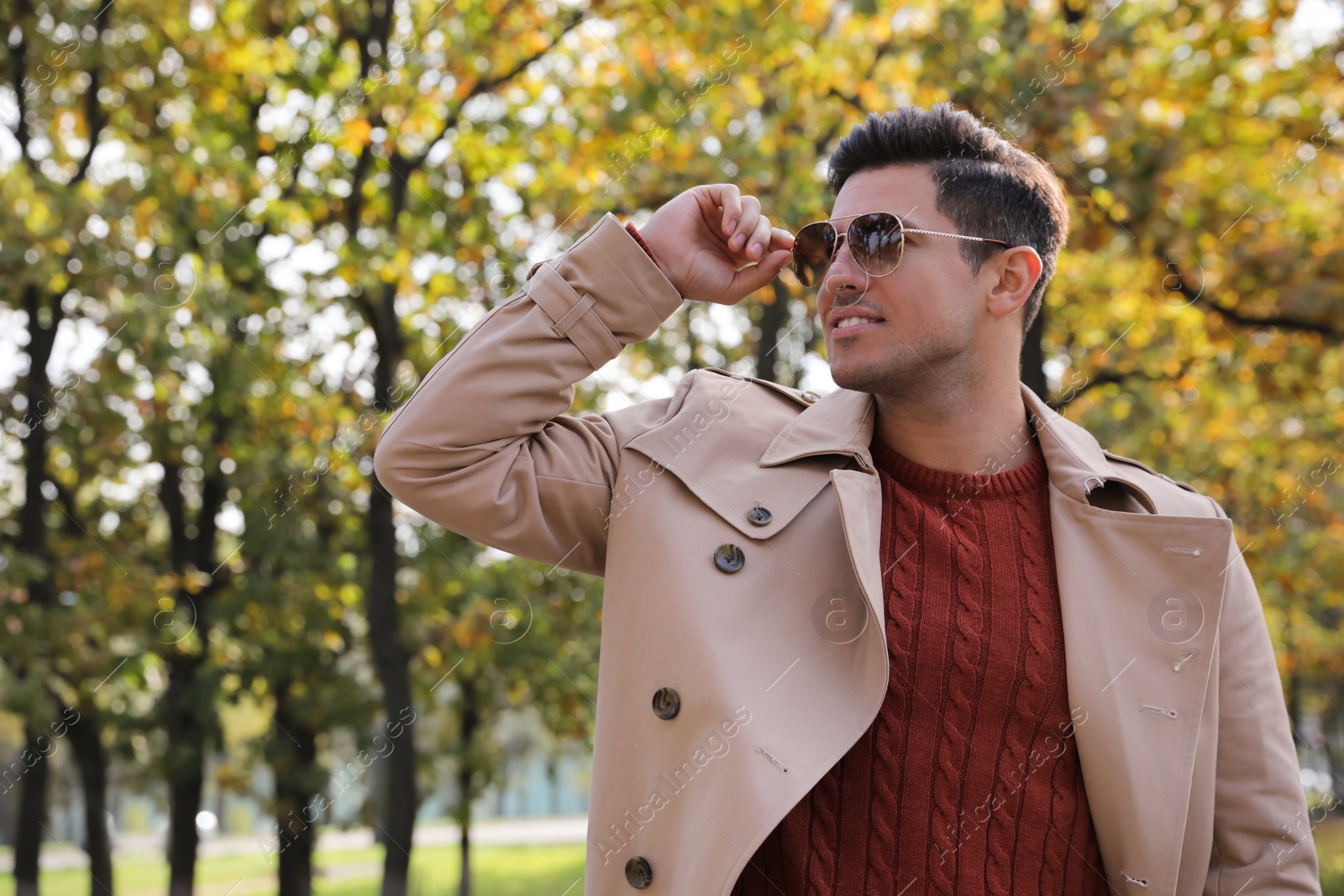 Photo of Handsome man walking in park on autumn day