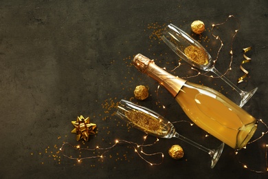 Photo of Flat lay composition with bottle of champagne for celebration on grey stone background. Space for text