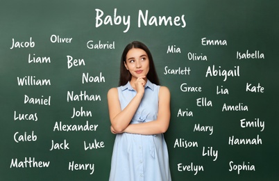 Image of Thoughtful pregnant woman choosing name for her child. Future mother near green chalkboard with different names