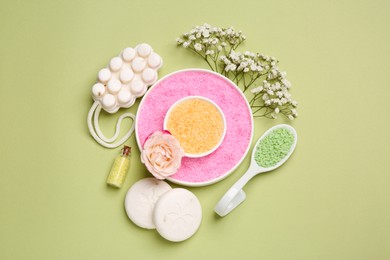 Sea salt, soap bars and beautiful flowers on olive background, flat lay