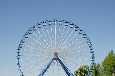 Photo of Amusement park. Beautiful large Ferris wheel against blue sky
