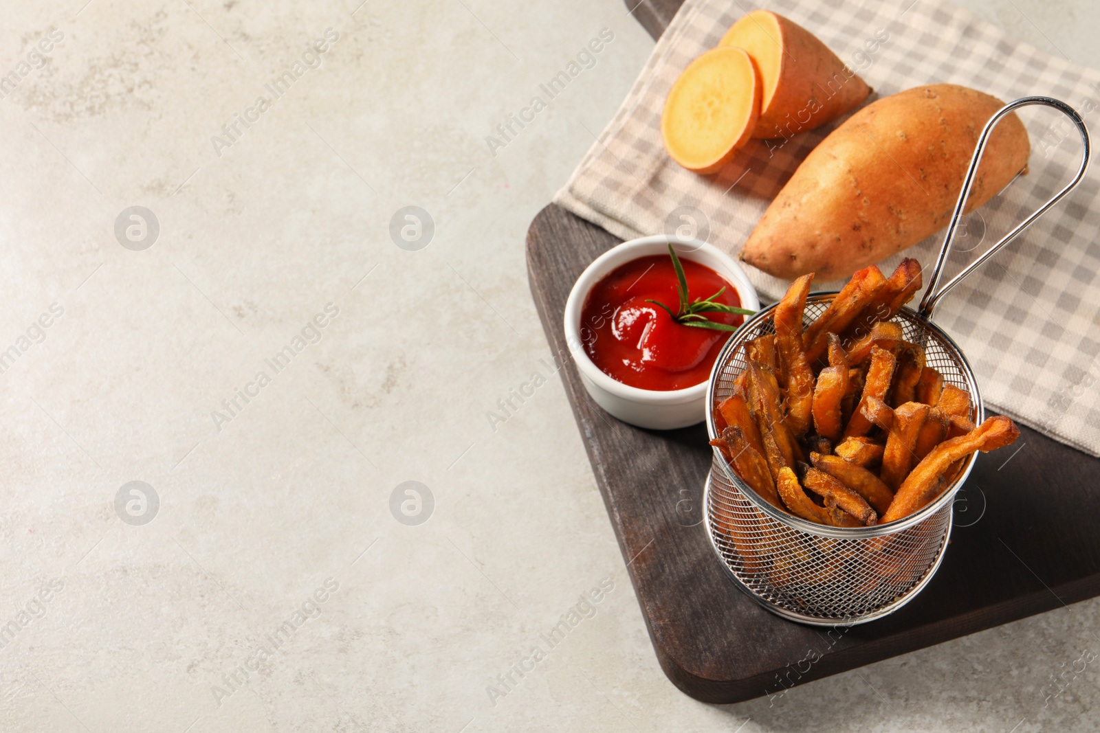 Photo of Sweet potato fries and ketchup on light grey table, above view. Space for text