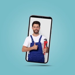 Image of Plumber looking out of smartphone and showing thumbs up on light blue background