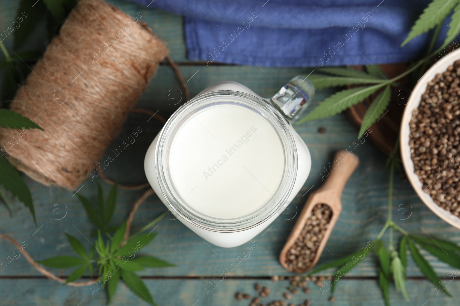 Photo of Flat lay composition with fresh hemp milk on light blue wooden table