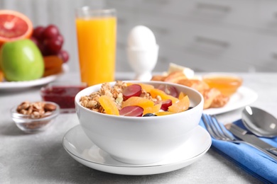 Photo of Delicious granola with fruits served on white table