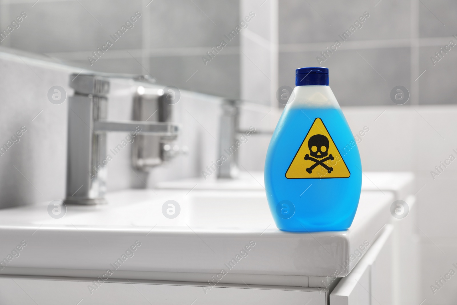 Photo of Bottle of toxic household chemical with warning sign in bathroom, space for text