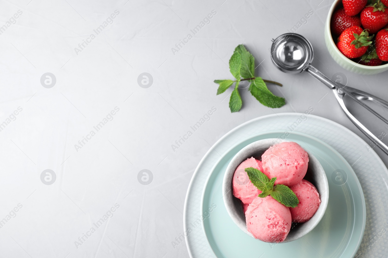 Photo of Flat lay composition with pink ice cream and strawberries on light table. Space for text