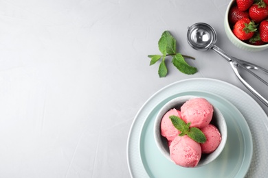 Flat lay composition with pink ice cream and strawberries on light table. Space for text