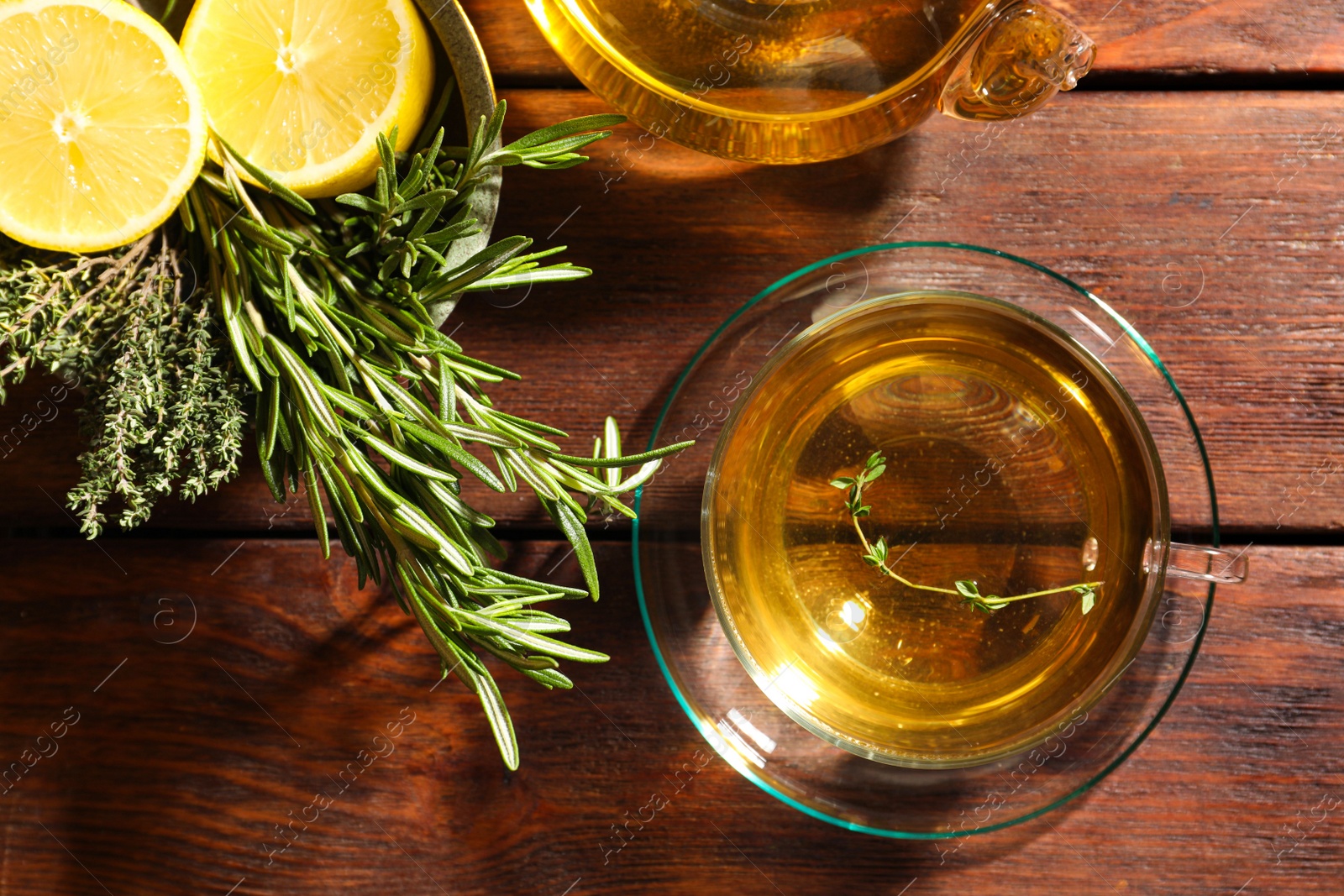 Photo of Aromatic herbal tea, fresh rosemary, thyme and lemon on wooden table, flat lay