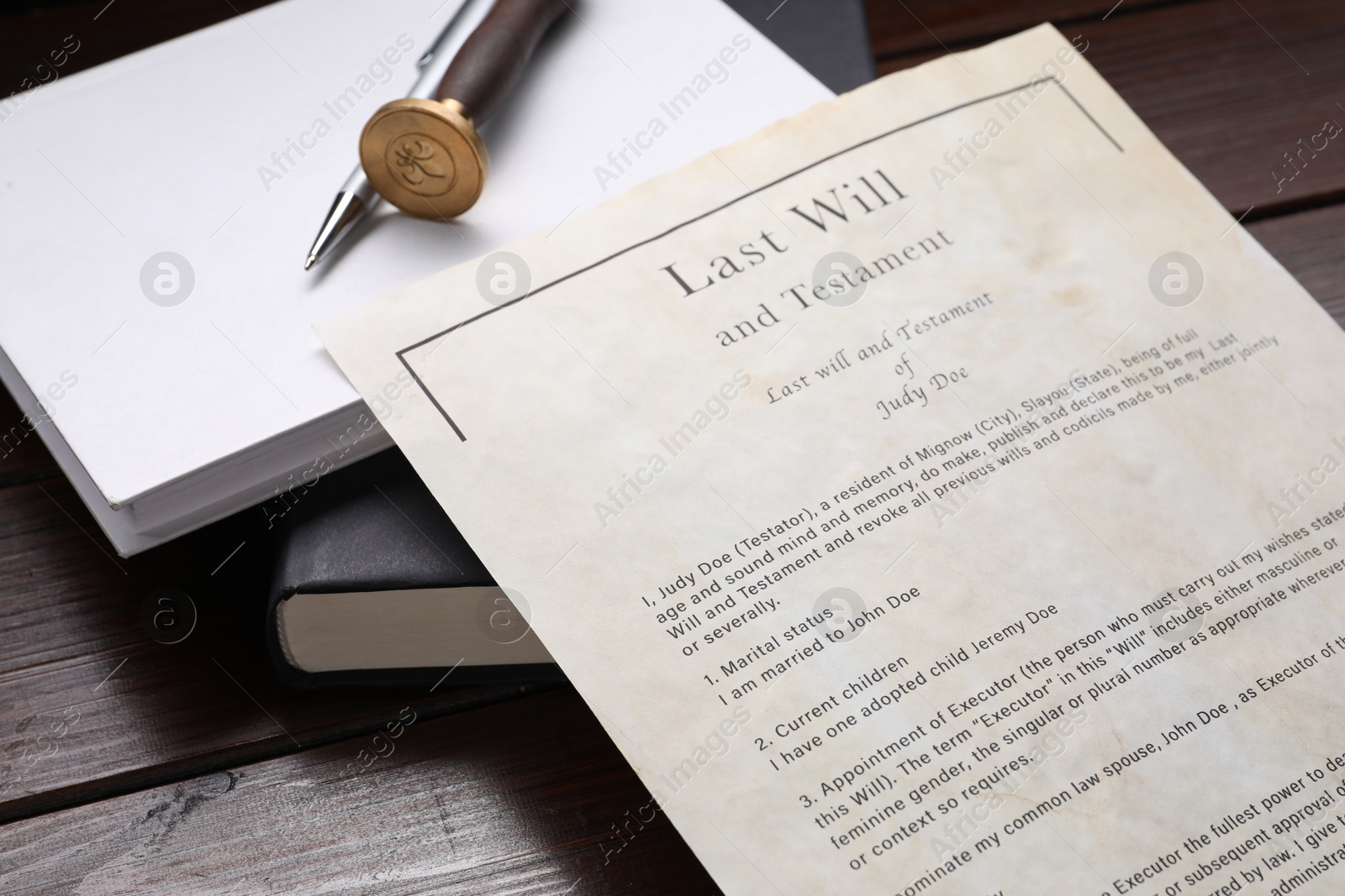 Photo of Last Will and Testament, books, stamp seal and pen on wooden table, closeup