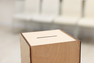 Photo of Wooden ballot box on blurred background, closeup. Space for text