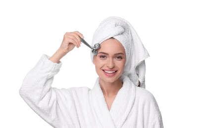 Photo of Young woman massaging her face with metal roller isolated on white