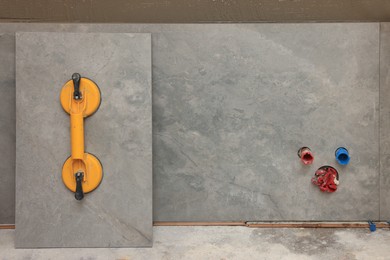 Yellow suction plate attached to tile near wall indoors