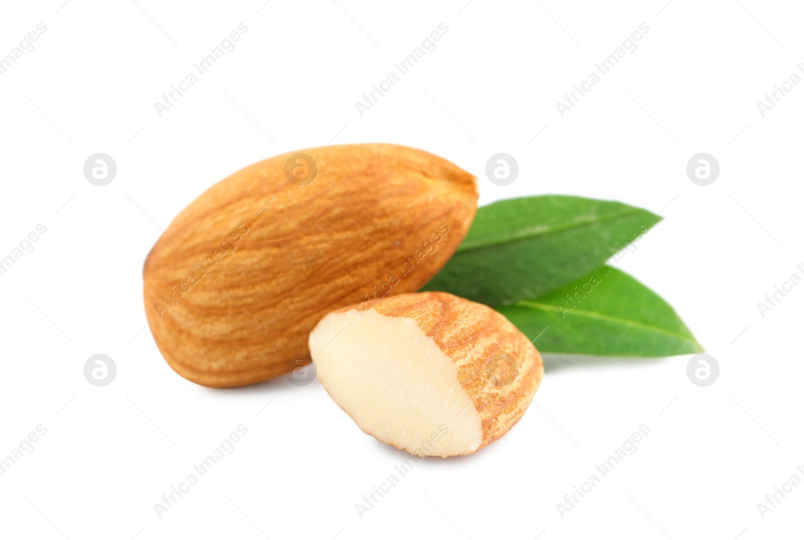 Photo of Organic almond nuts and green leaves on white background. Healthy snack