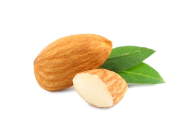 Organic almond nuts and green leaves on white background. Healthy snack