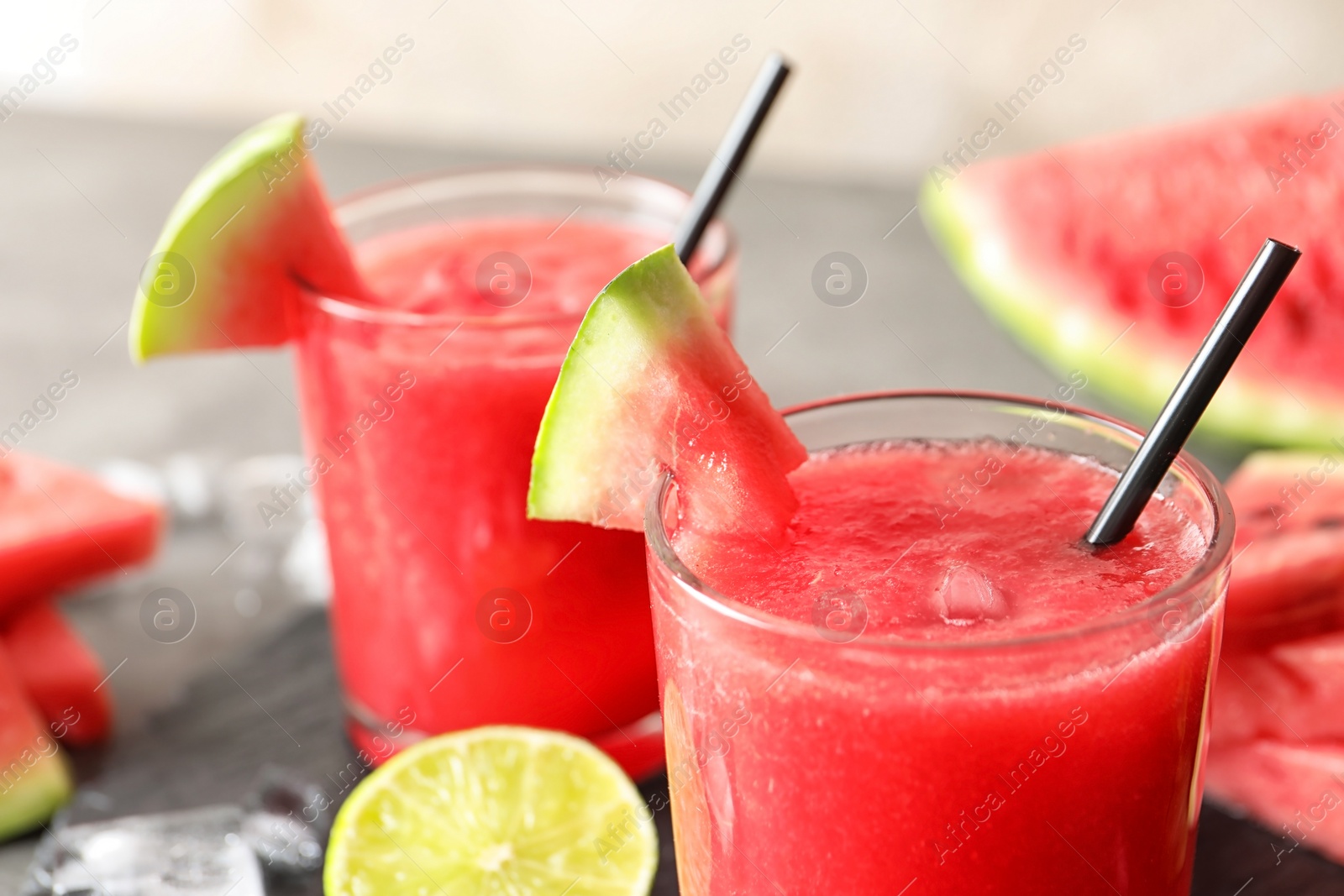 Photo of Tasty summer watermelon drink in glasses served on table, closeup