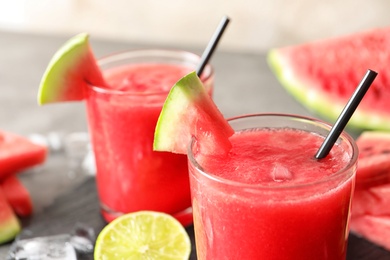 Photo of Tasty summer watermelon drink in glasses served on table, closeup