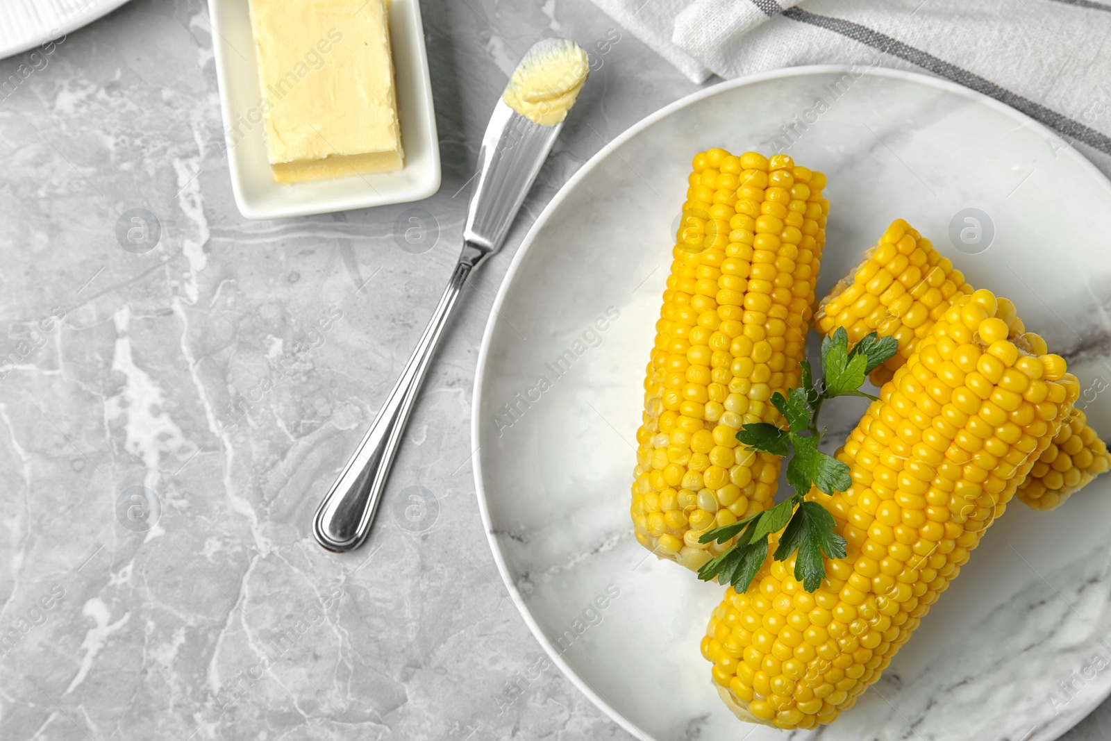 Photo of Flat lay composition of boiled corn cobs on light grey marble table