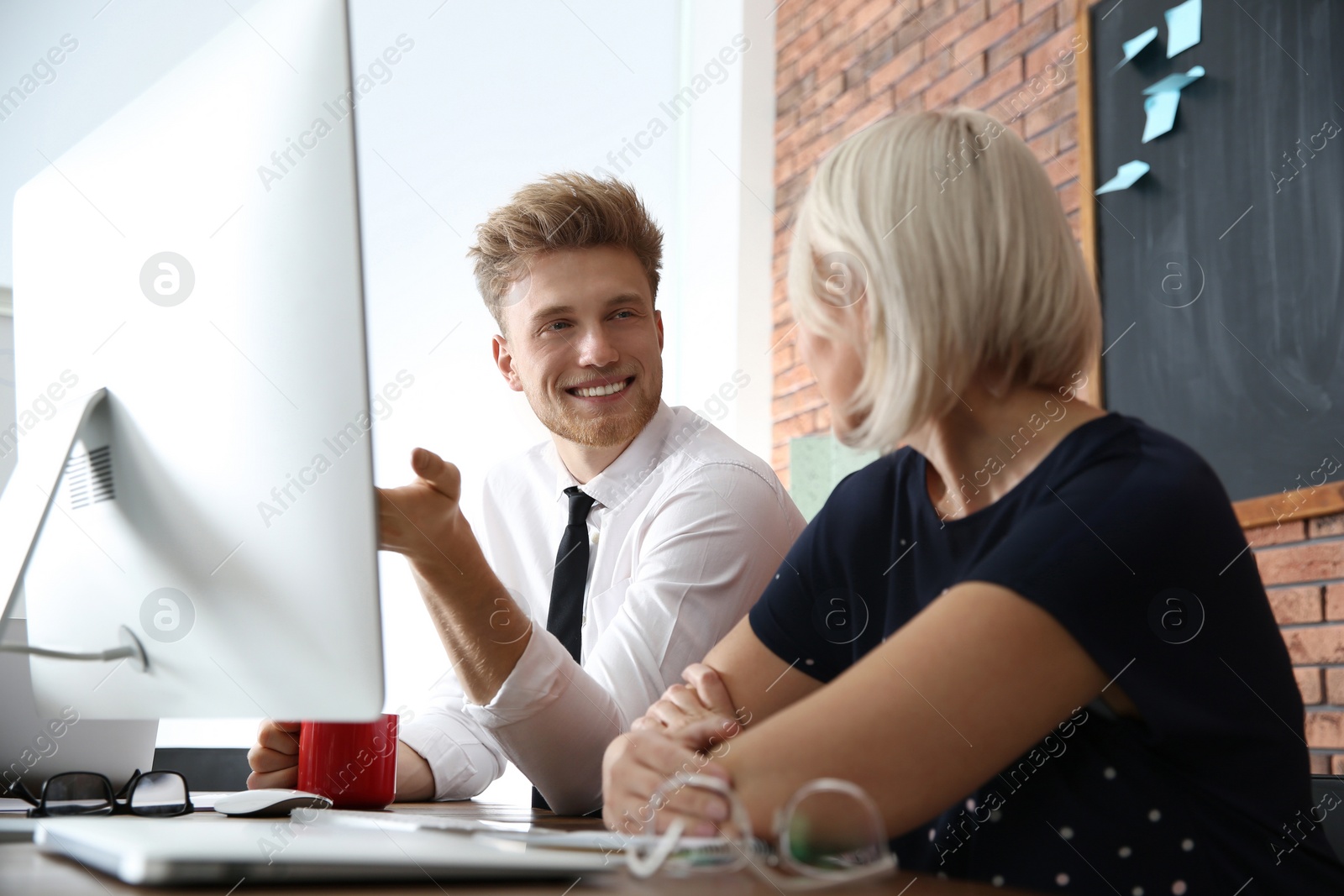 Photo of Business people working on computer at table in office. Professional communication