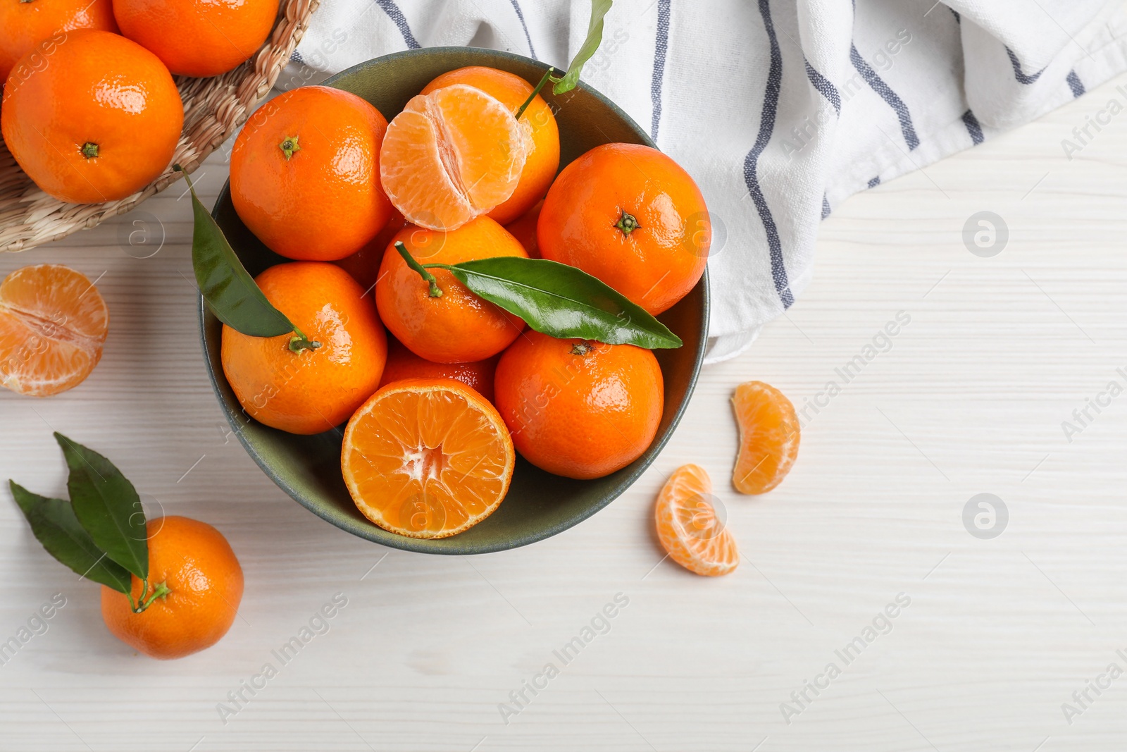 Photo of Delicious tangerines with green leaves on white wooden table, flat lay. Space for text