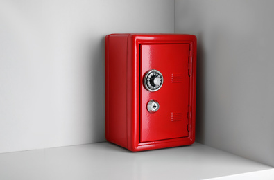 Photo of Red steel safe with mechanical combination lock on shelf