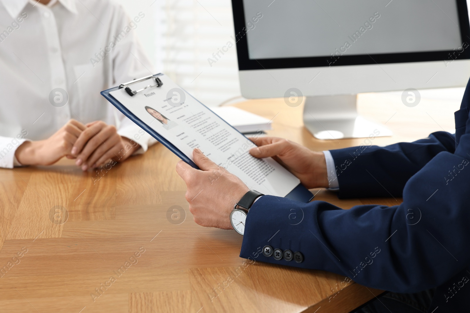 Photo of Human resources manager reading applicant's resume in office, closeup