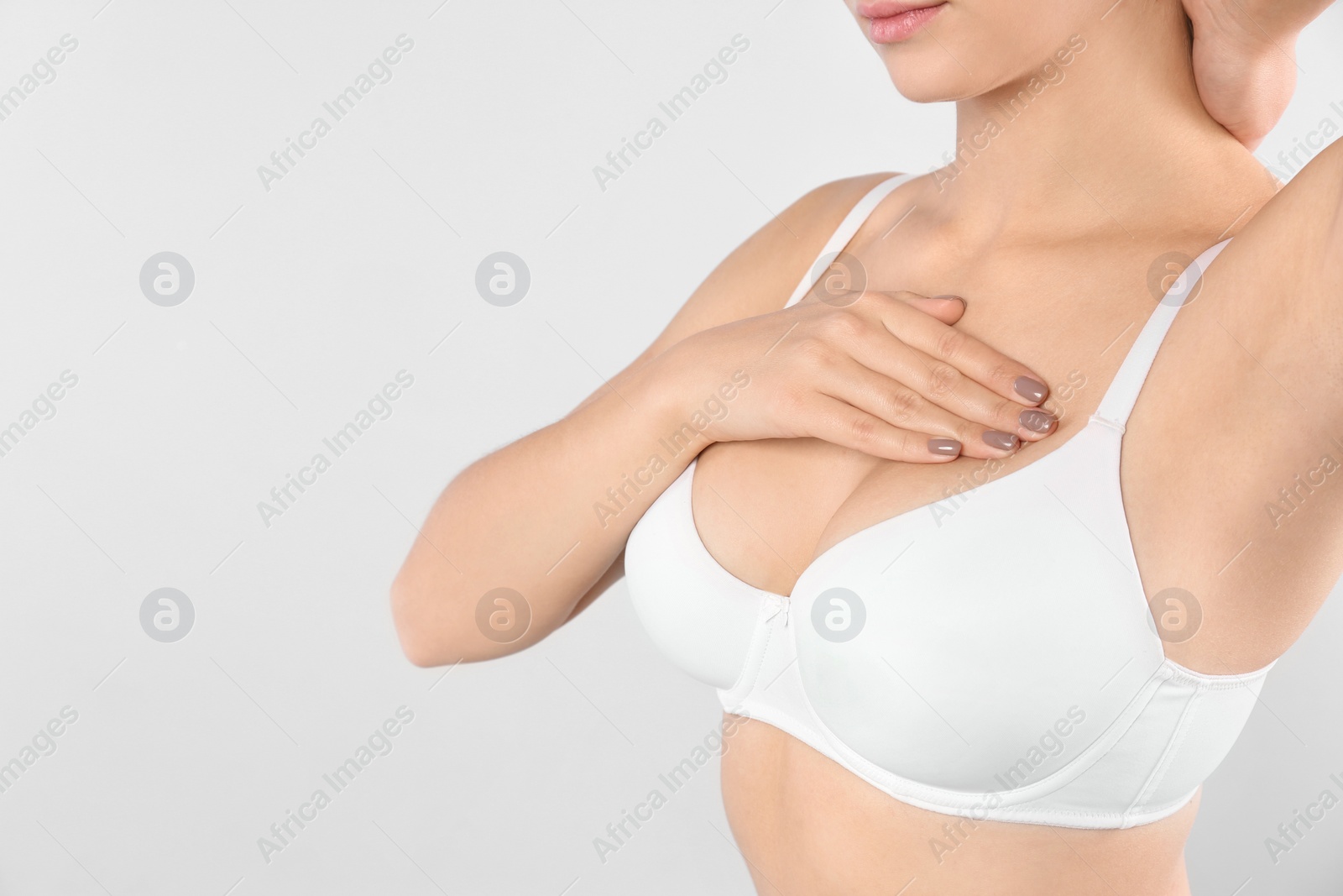 Photo of Woman checking her breast on white background, closeup. Space for text