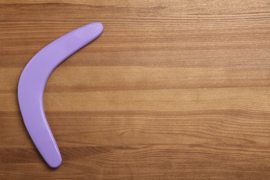 Photo of Boomerang on wooden background, top view. Space for text