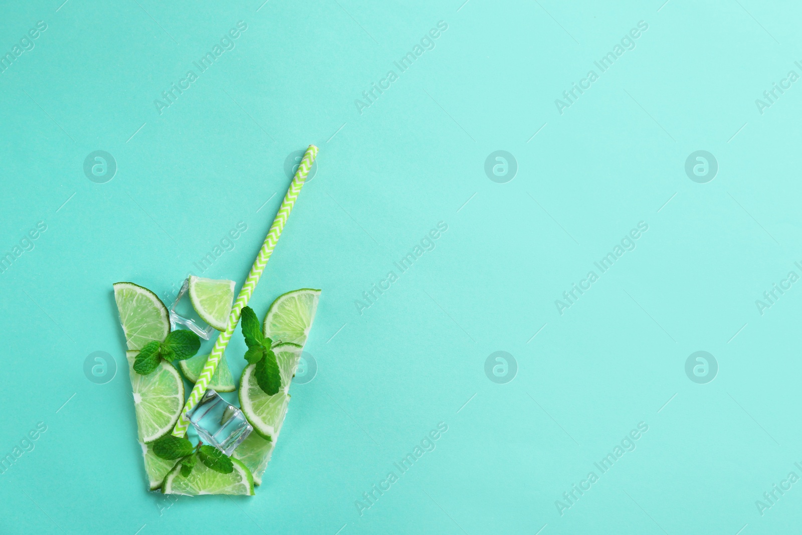 Photo of Creative lemonade layout with lemon slices, mint and ice on turquoise background, top view. Space for text