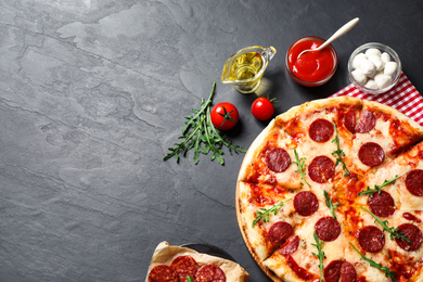 Photo of Flat lay composition with hot pepperoni pizza on dark table. Space for text