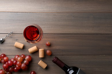 Photo of Wine, corks, grapes and corkscrew on wooden table, flat lay. Space for text