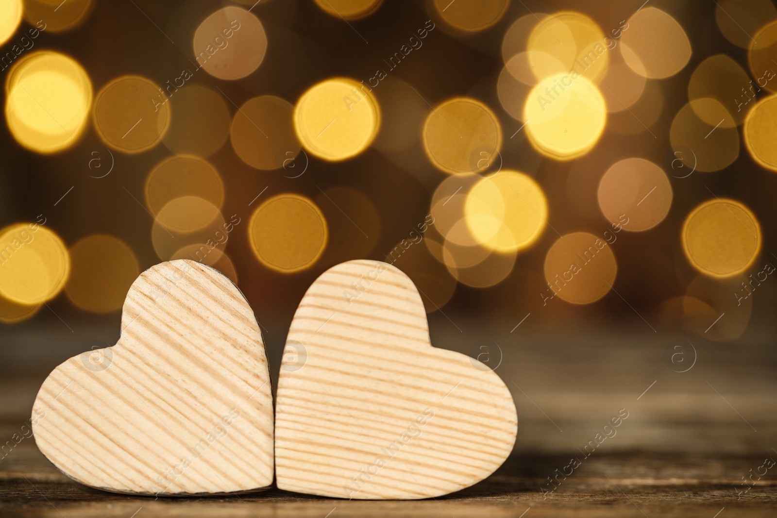 Photo of Wooden decorative hearts on table against blurred background, space for text. Valentine's Day