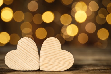 Photo of Wooden decorative hearts on table against blurred background, space for text. Valentine's Day