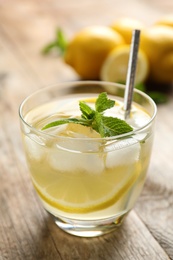 Photo of Natural lemonade on wooden table, closeup. Summer refreshing drink