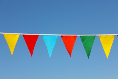 Bunting with colorful triangular flags against blue sky