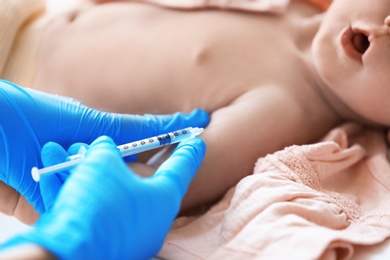 Photo of Doctor vaccinating baby in clinic, closeup