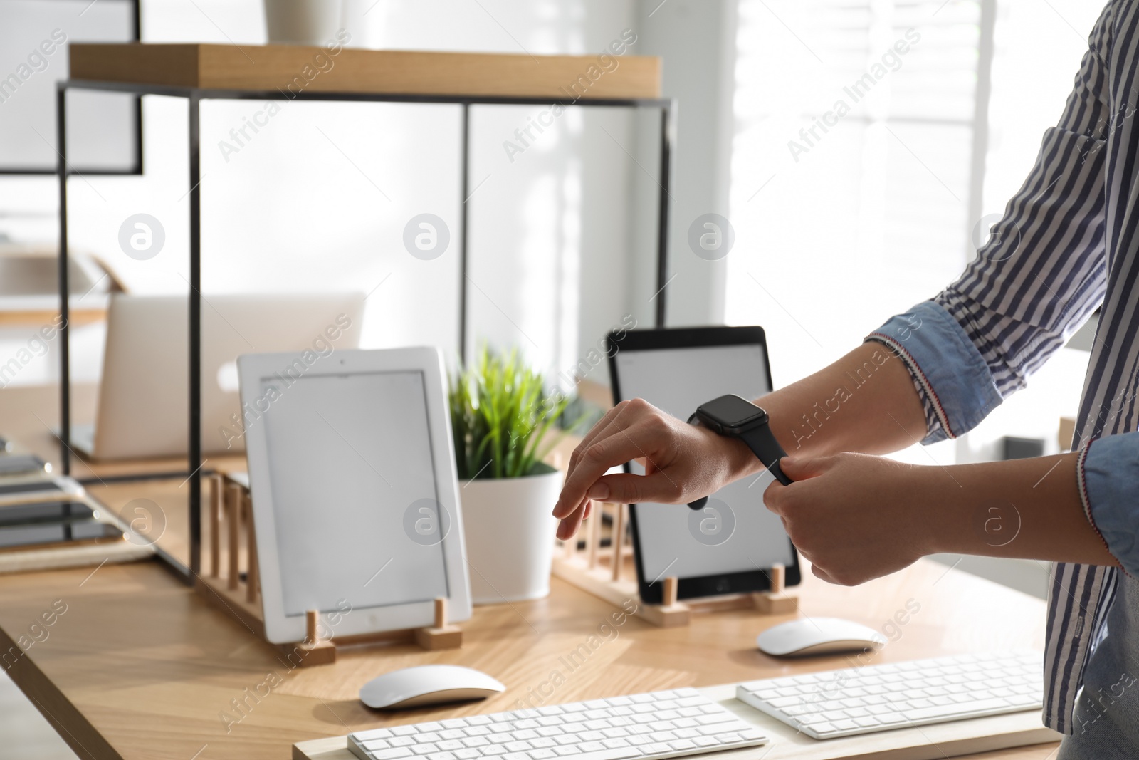 Photo of MYKOLAIV, UKRAINE - AUGUST 17, 2020: Woman choosing Smart Watch in Apple Store, closeup