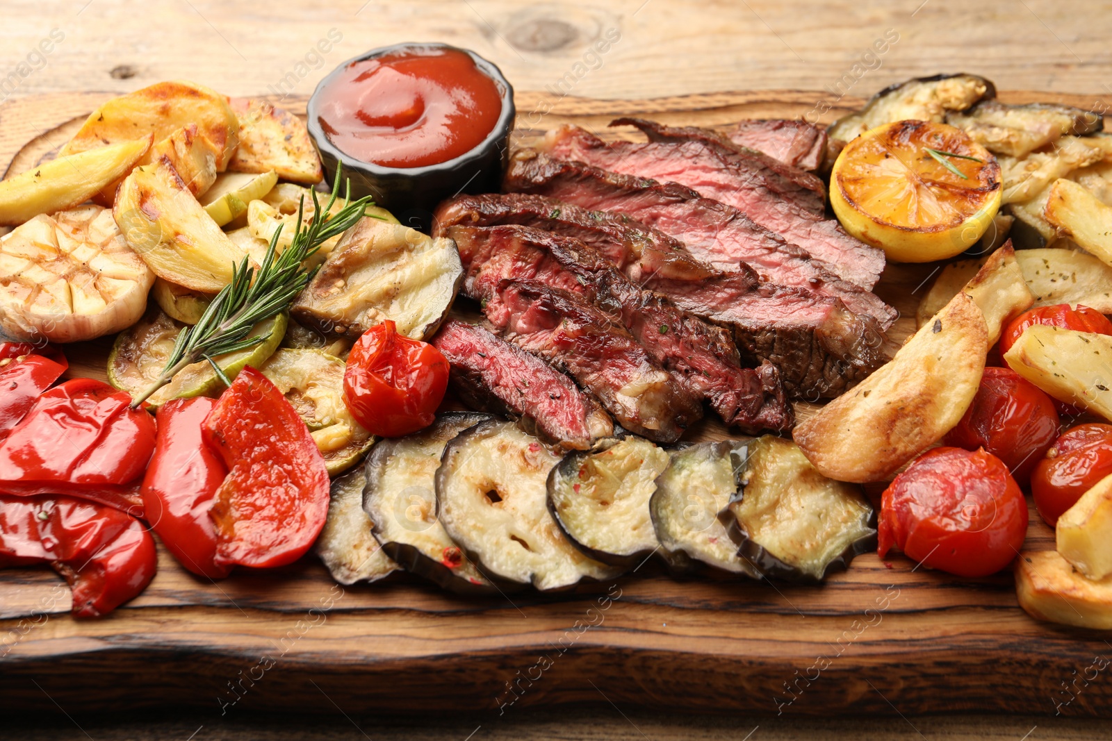 Photo of Delicious grilled beef with vegetables, tomato sauce and spices on table, closeup