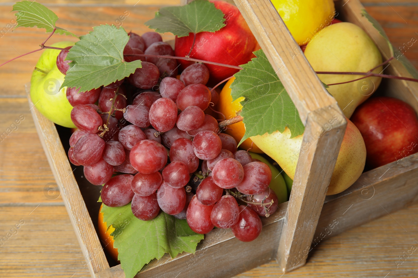 Photo of Crate with different fruits on wooden table, above view