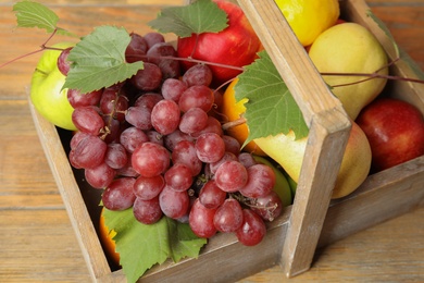 Photo of Crate with different fruits on wooden table, above view