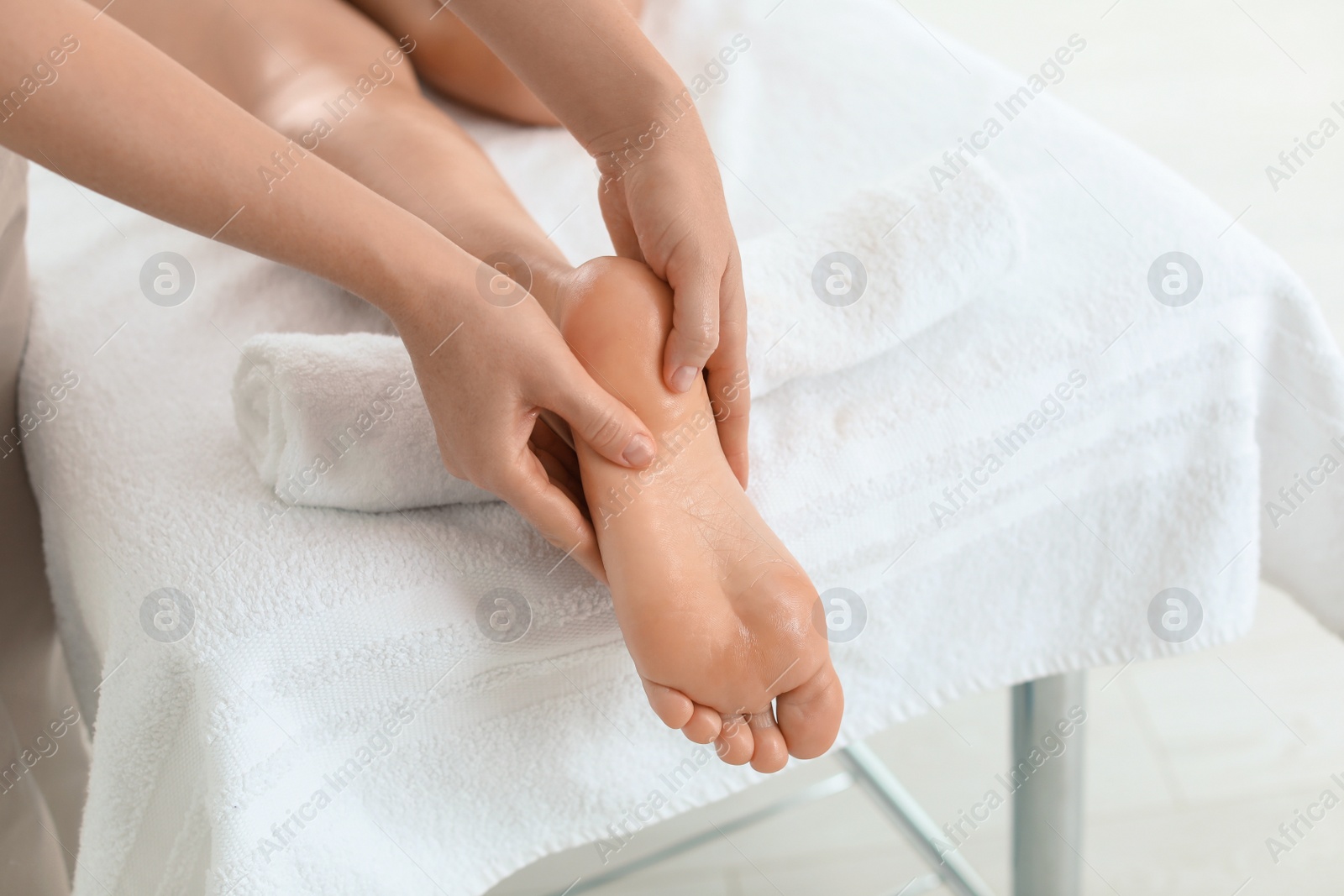 Photo of Woman receiving foot massage in wellness center, closeup