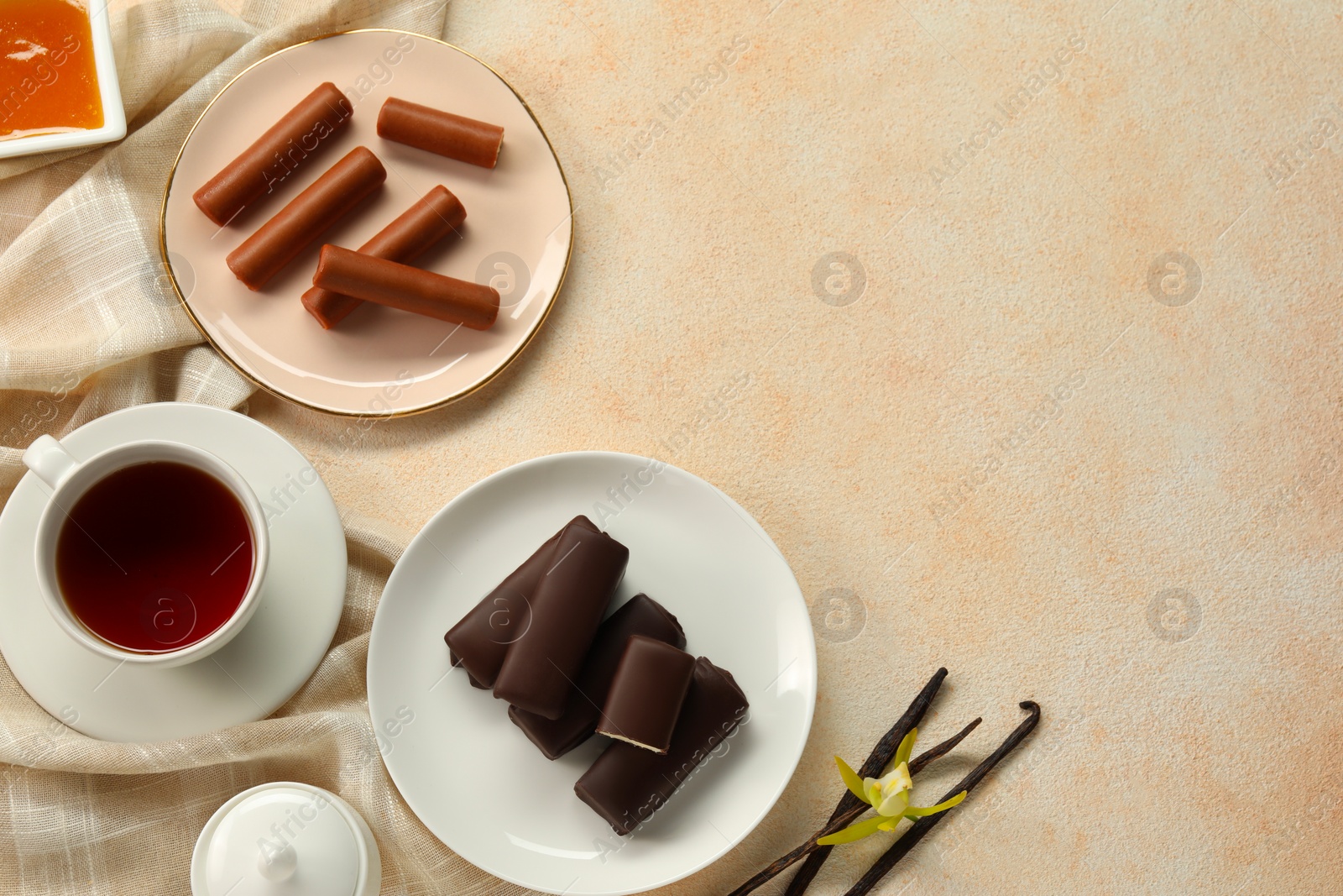 Photo of Glazed vanilla curd cheese bars served on beige table, flat lay. Space for text