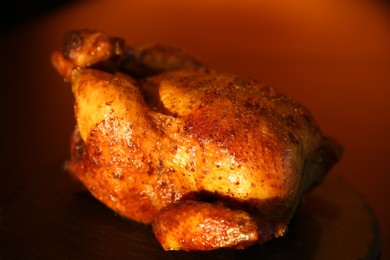 Photo of Delicious grilled whole chicken on black table, closeup
