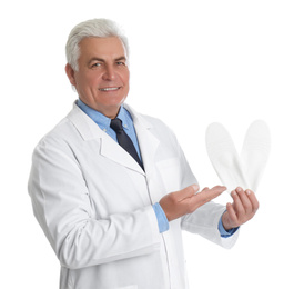 Photo of Male orthopedist showing insoles on white background