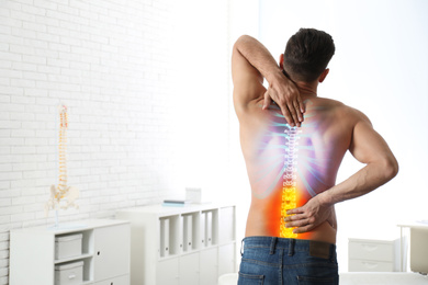 Image of Man suffering from pain in spine in orthopedist's office. Space for text