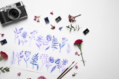 Photo of Flat lay composition with floral picture and watercolor paints on white background